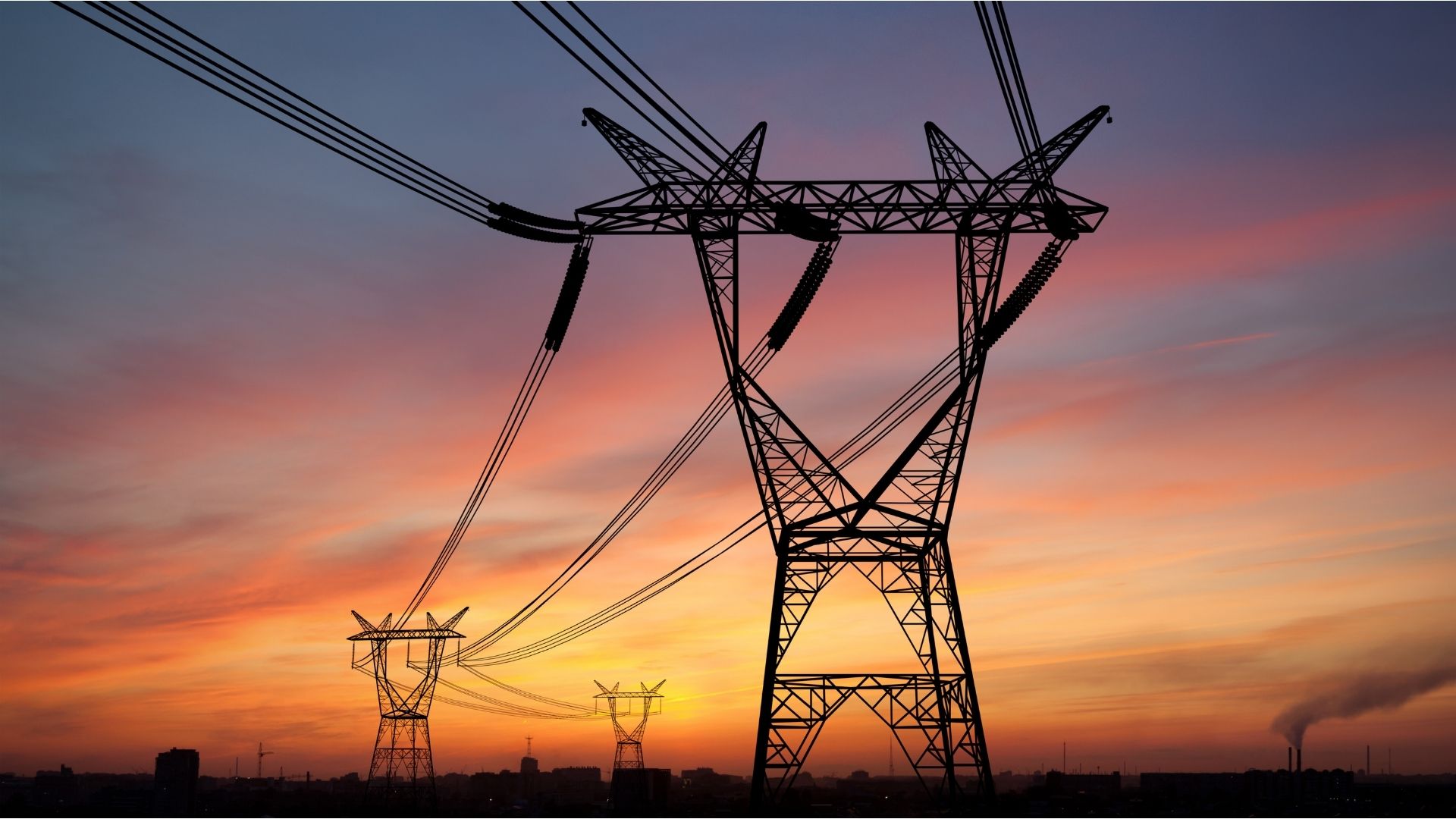 High-voltage power lines and utility poles at sunset